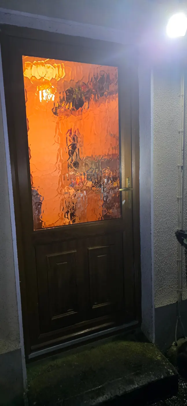 Front door with decorative glass at night during an emergency lockout