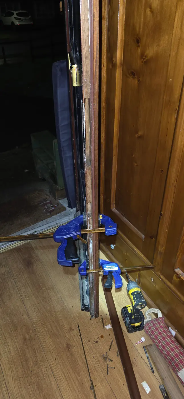 Door frame being repaired with clamps and professional tools